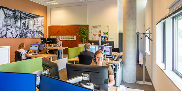 Een kantoor met werknemers die werken achter beeldschermen, foto gemaakt door fotograaf Kees Winkelman